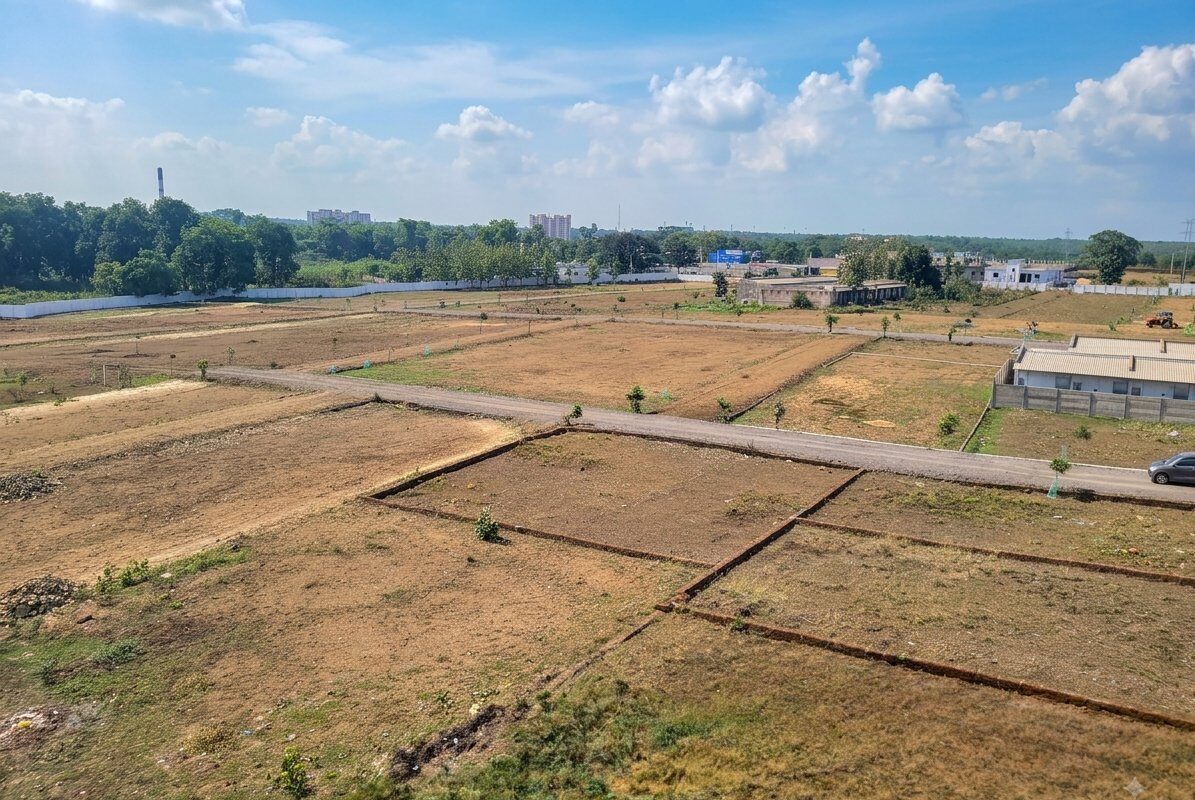 Demarcated plots, internal road and boundary wall inside a Swarna Properties layout